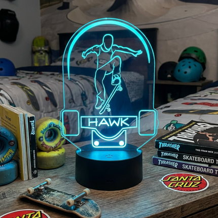 Neon light with 'Hawk' branding on a desk with skateboarding items